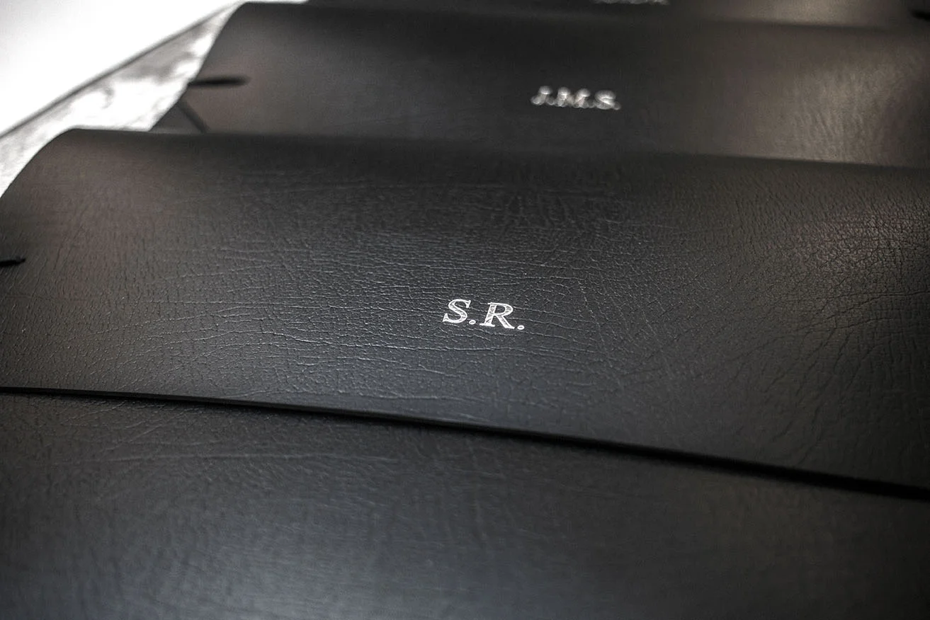 close up of the silver foil embossing on black leather laptop case sleeves