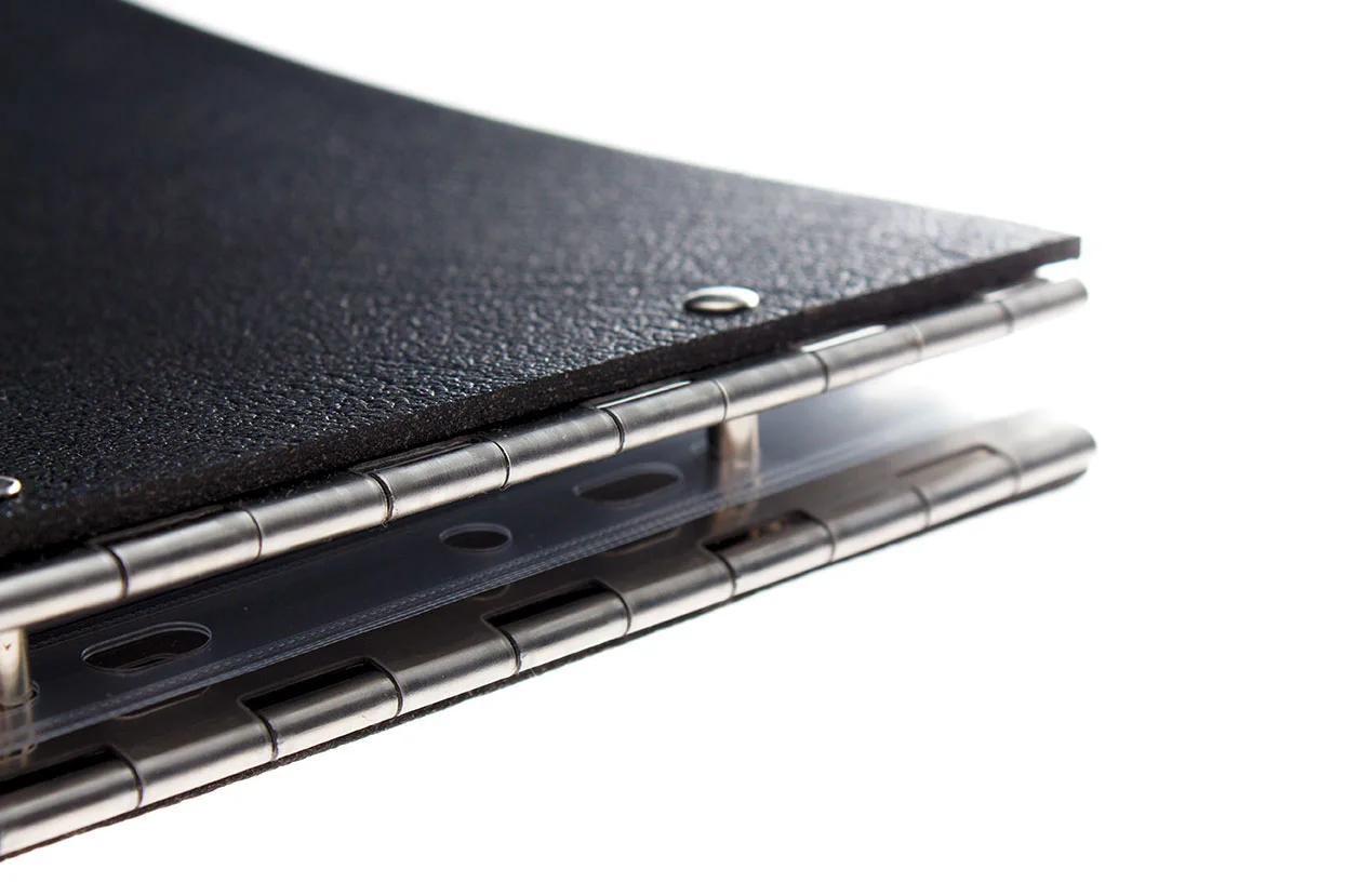 Close up of the steel hinges on a black leather A3 landscape display portfolio, showing the how the binding posts secure your work in the folder