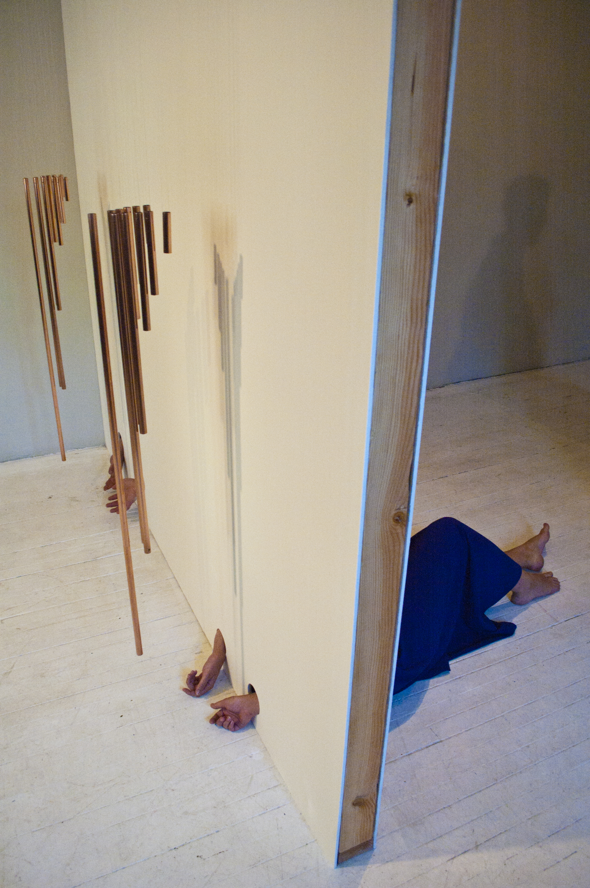 New Colossus 1:00 hr, copper, sheet rock, monofilament, 2012. installation view: Happy Collaborationist Exhibition Space Photography by Josh Korby New Colossus, first exhibited for the Rapid Pulse International Performance Festival satellite Triage, responds to the shifting opinion of immigration through history. The copper pipes hang freely on the opposite side of the wall of Jesus Mejia & Ruth, chiming when the door opens. Referencing the sonnet written by Emma Larazus inscribed on the base of the Statue of Liberty, Jesus Mejia & Ruth combine the arrest of the body with the free conduct of wind. Written by Larazus, "Give me your tired, your poor,Your huddled masses yearning to breathe free," Jesus Mejia & Ruth describe two motions: the invitation represented in the Statue of Liberty and the surrender required to call this country home.