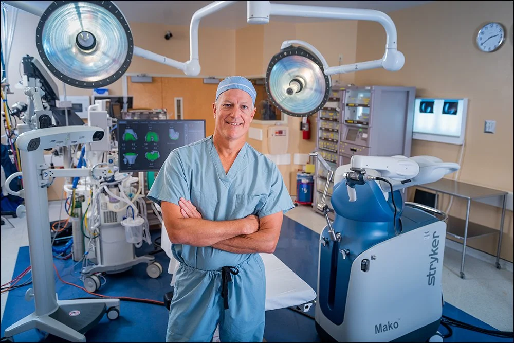 Surgeon standing in operating room with advanced medical equipment and surgical lights