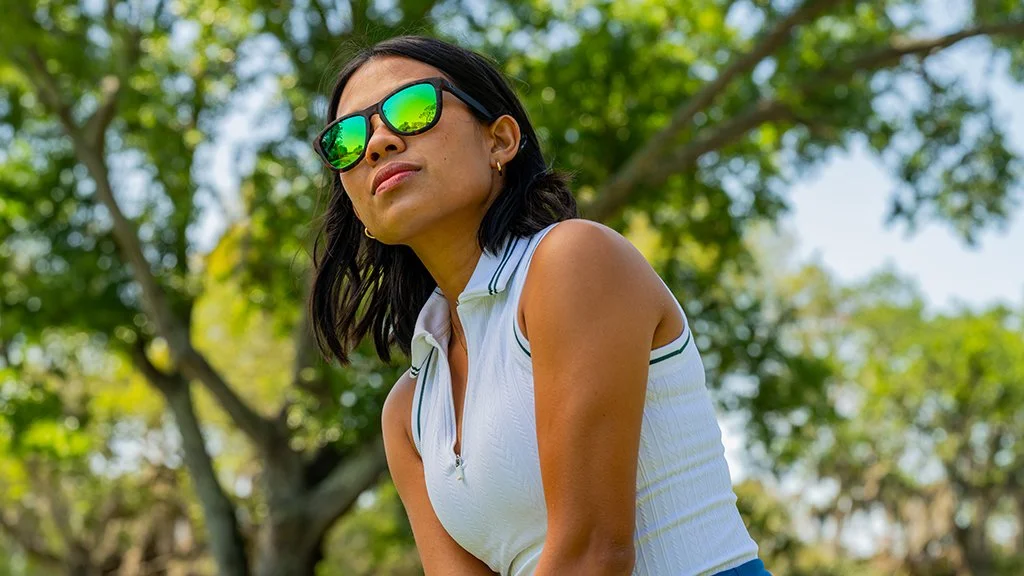 female golfer wearing reflective sunglasses during commercial golf photoshoot on course
