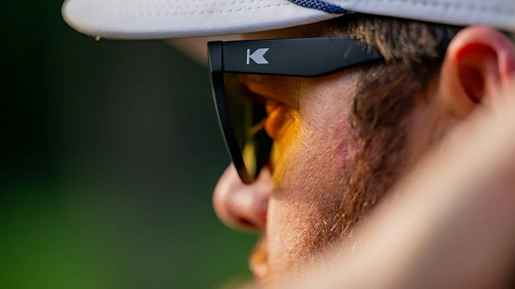 Alt Text: close up of PGA Tour golfer Harry Higgs wearing sunglasses with warm light reflection