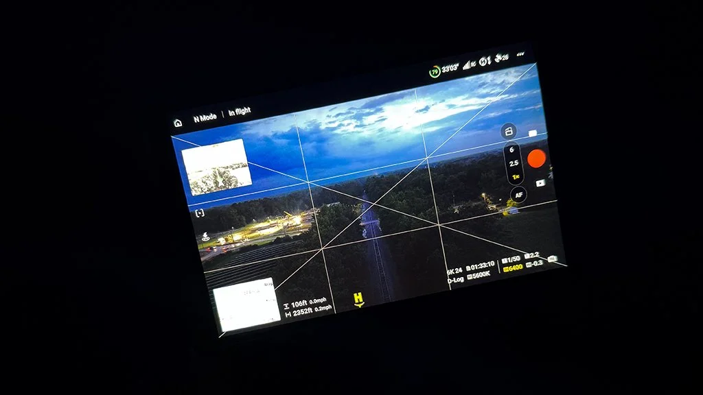 DJI drone controller displaying the live camera view while preparing to film the CSX America 250 Executive Train after sunset.
