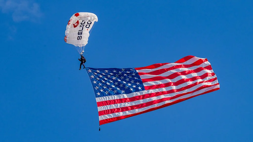 Kevin Engel of Team Fastrax parachutes into the Pars With Patriots Invitational carrying a 50-foot American flag.