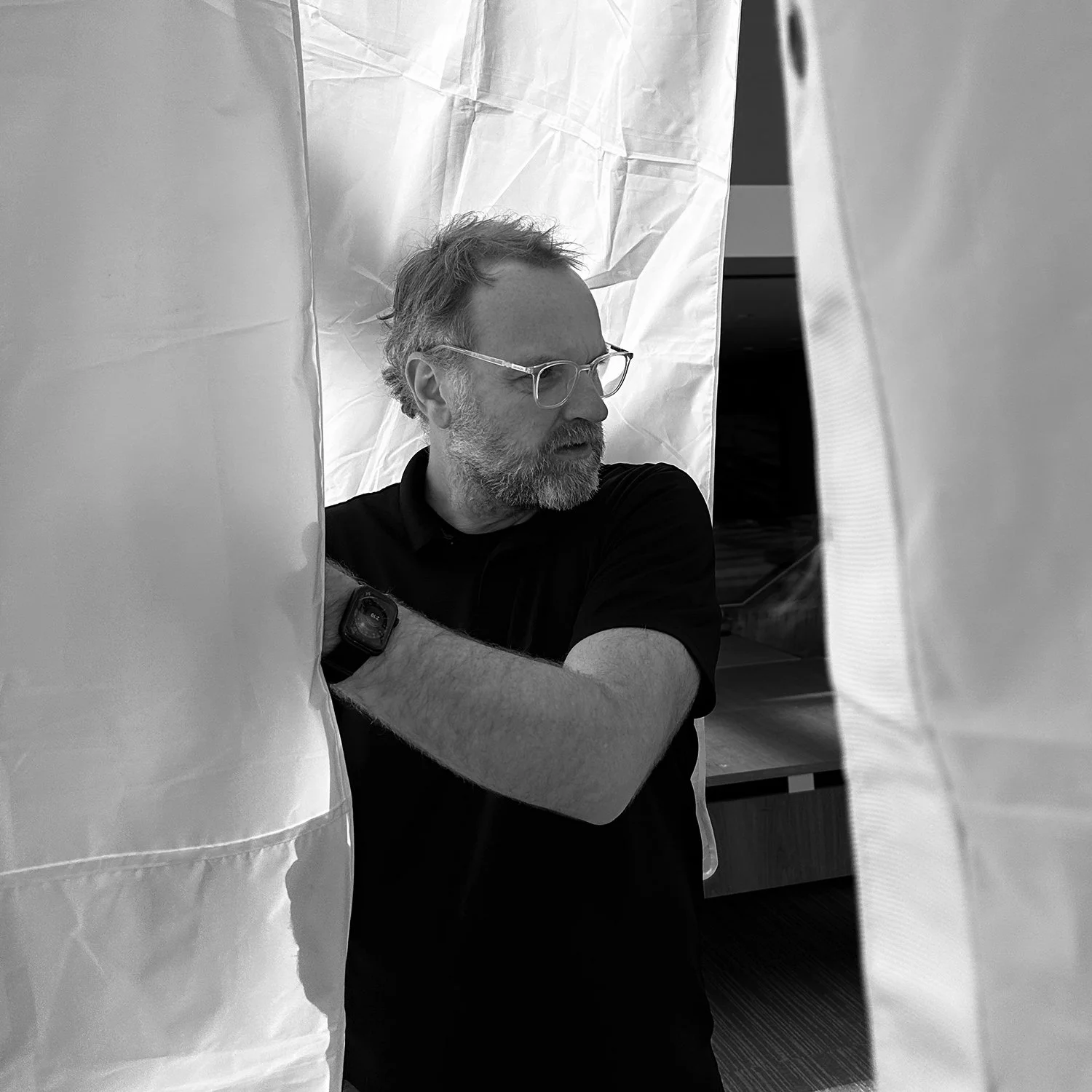 Director of photography adjusting diffusion for lighting setup during a commercial video production shoot