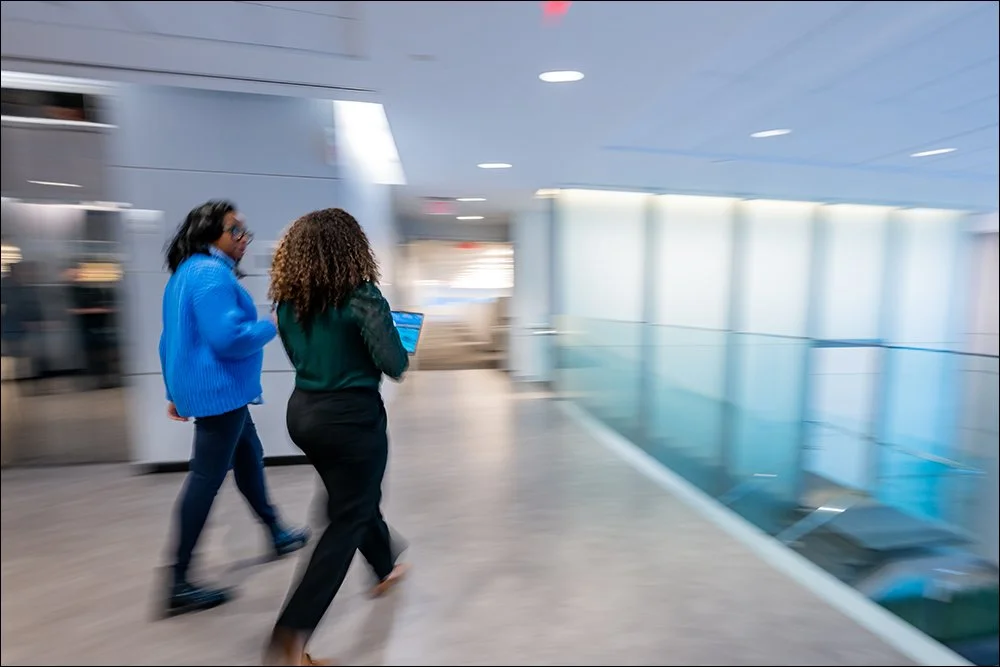 Employees walking through modern office hallway with motion blur