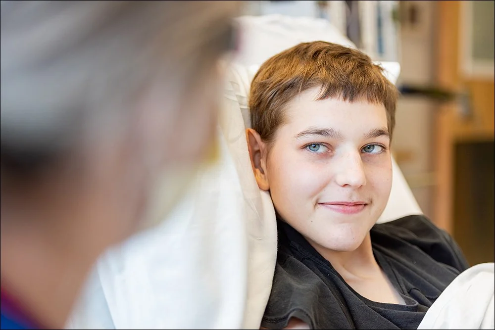 Pediatric patient resting in hospital bed looking toward camera in clinical environment