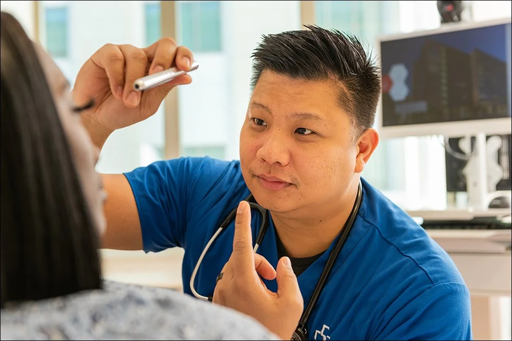 Doctor performing eye exam on patient during clinical consultation in exam room