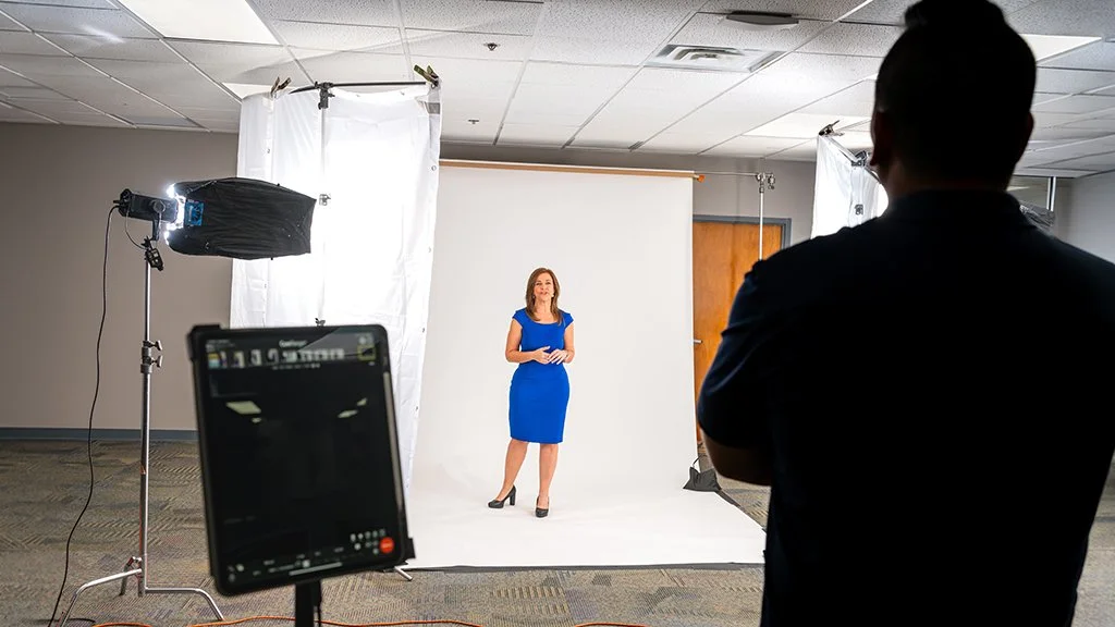 Jacksonville corporate photographer photographing WJXT on-camera talent on a white backdrop with studio lighting setup on location.