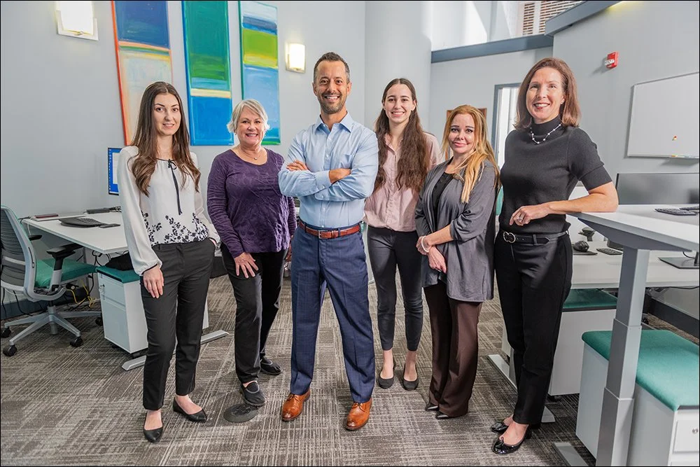 Corporate team standing together in modern office workspace environment