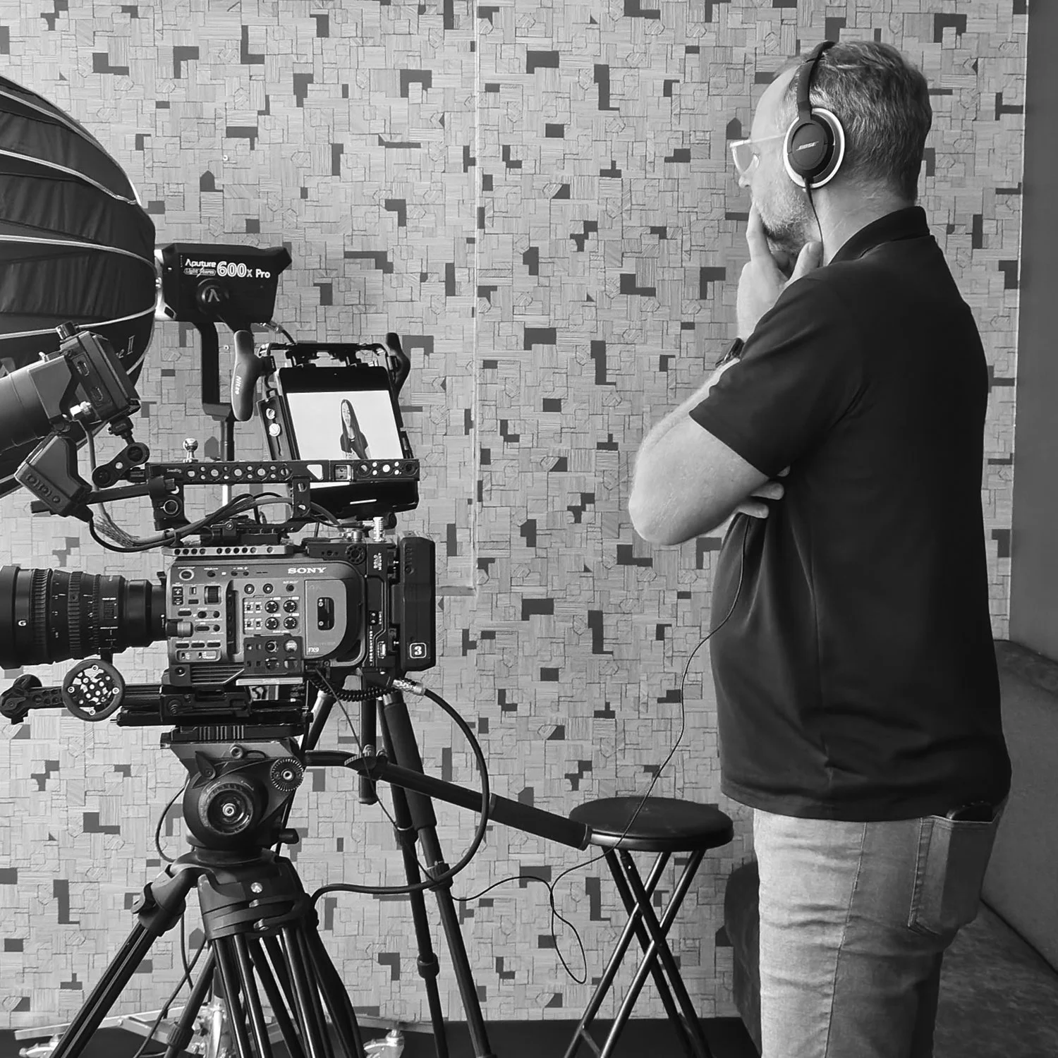 Director of photography monitoring interview setup with camera, lighting, and audio during corporate video production