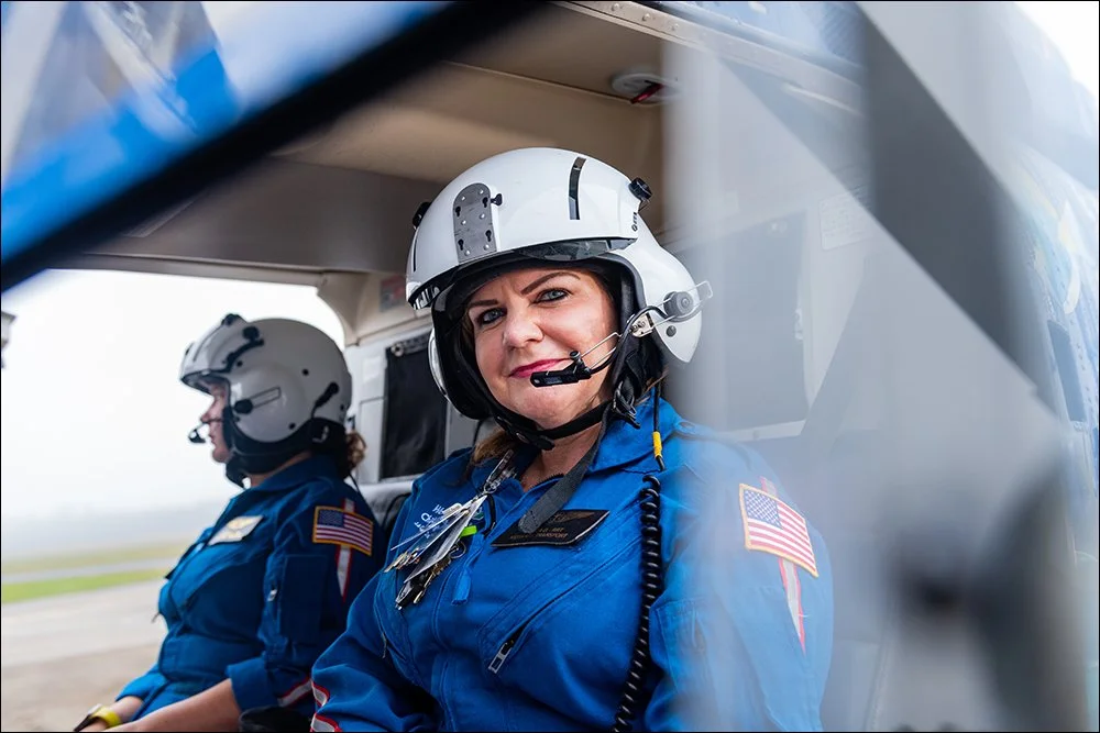 Air medical flight nurse inside helicopter cabin wearing flight helmet and headset