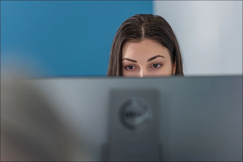 Professional working at computer in office environment with focused expression
