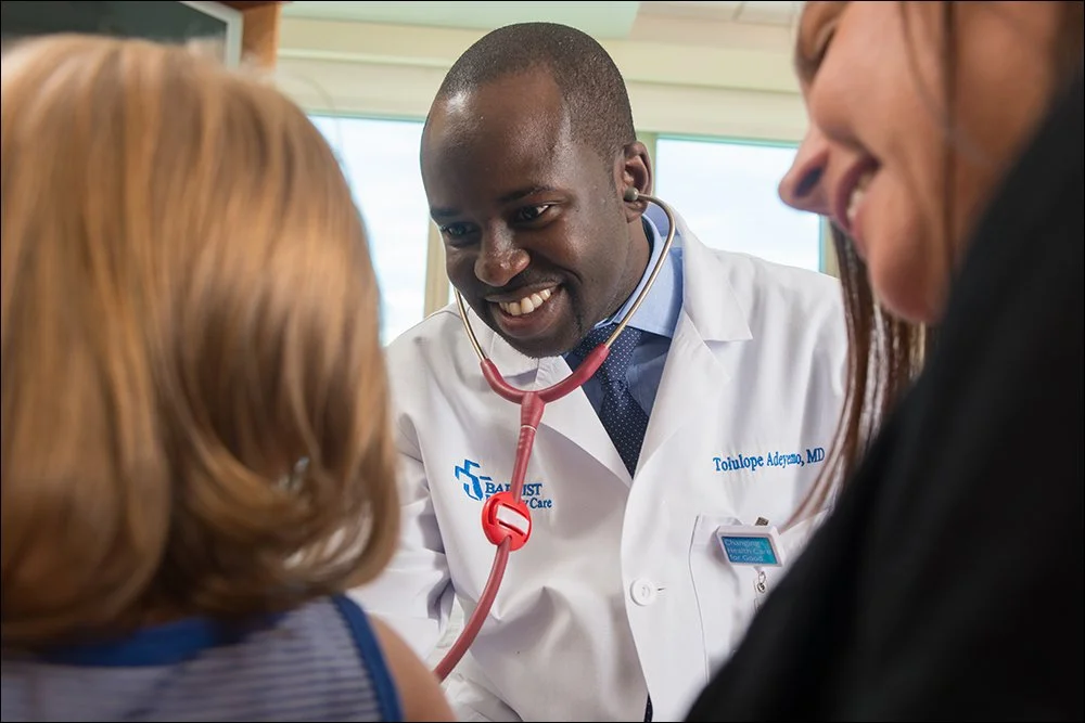 Doctor examining child with stethoscope during pediatric visit in clinic setting
