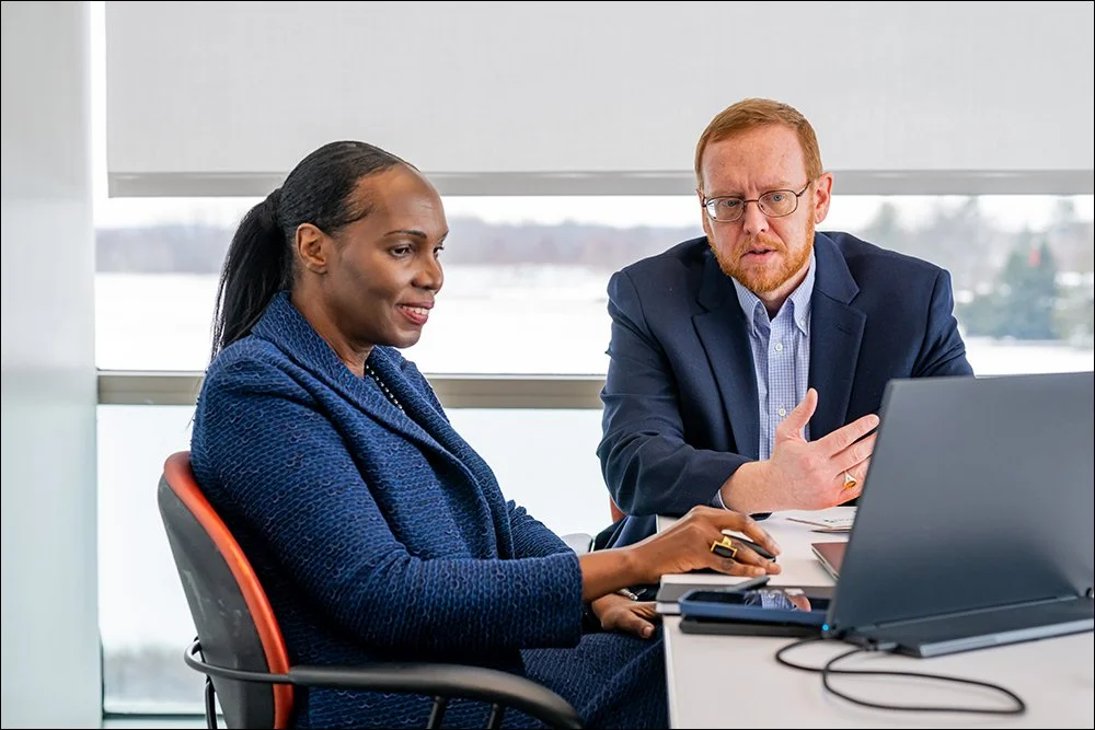 Two professionals collaborating during meeting in office with laptop