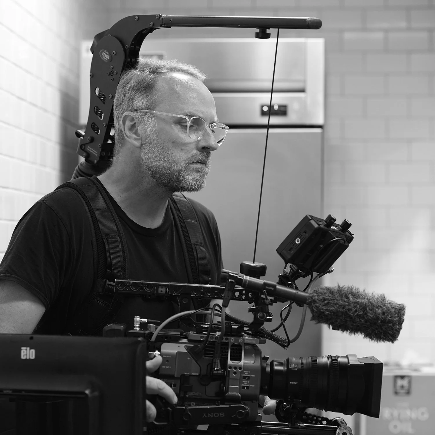 Cinematographer operating camera with Easyrig during a commercial video production shoot