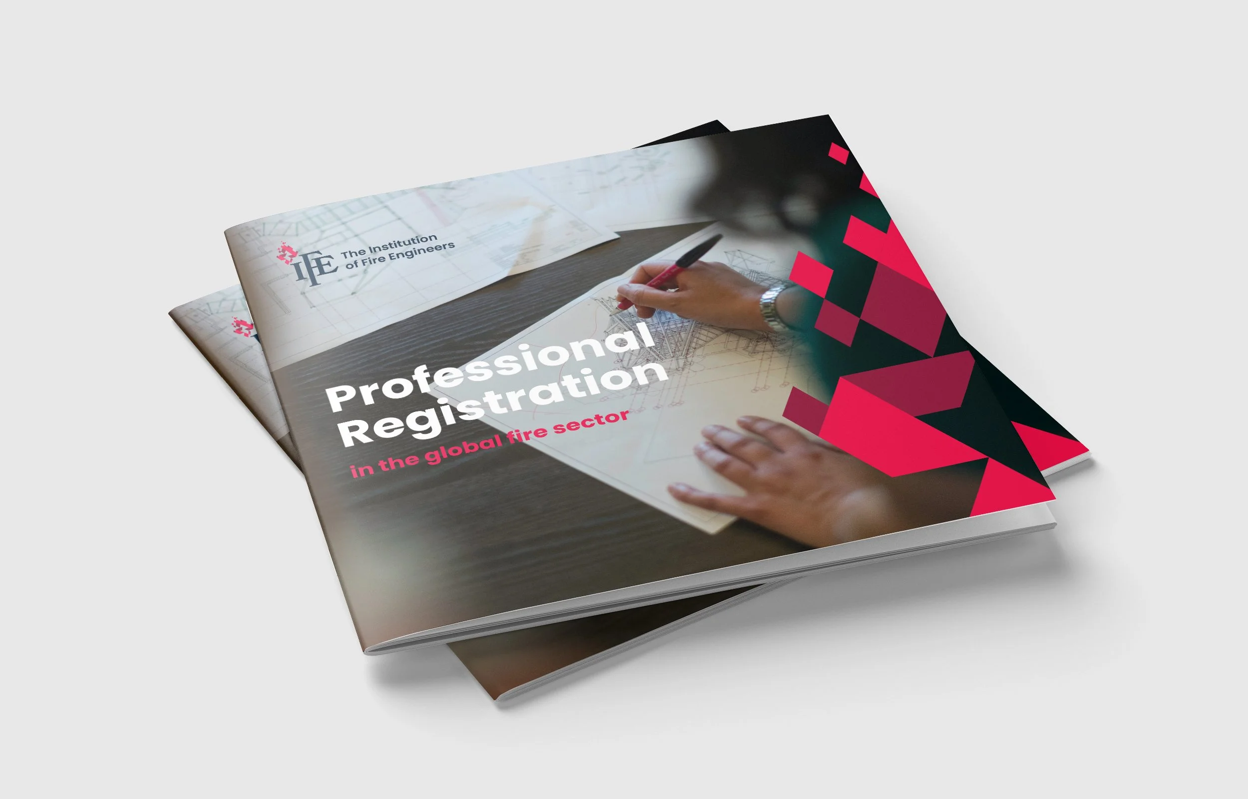 Open magazine titled 'Professional Registration' with a cover photo of a hand sketching architectural drawings on a desk.