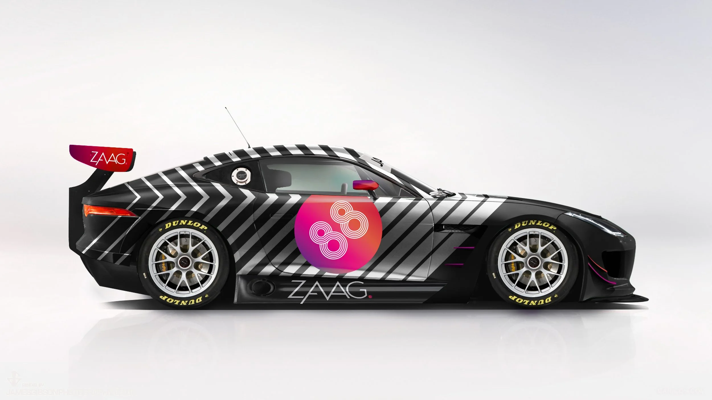 A black race car with white diagonal stripes, a pink, red, and purple circular logo on the side, and logos that read 'ZAAG' and 'DUNLOP.' The car has a prominent rear wing with the 'ZAAG' logo and yellow 'DUNLOP' tires.