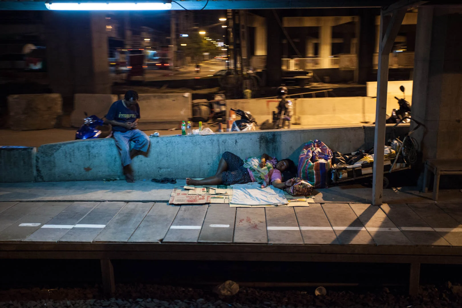 A station in the suburbs of Bangkok. I don't think they are waiting for train...
