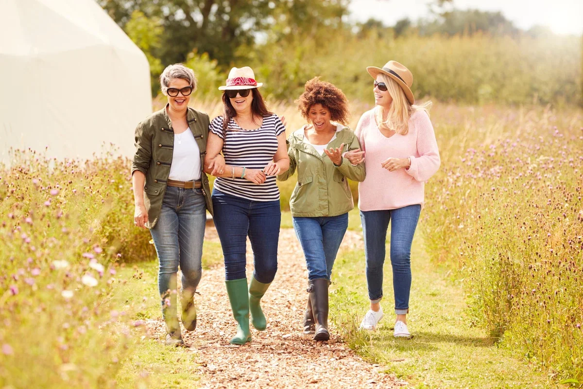group-of-mature-female-friends-walking-along-path.webp