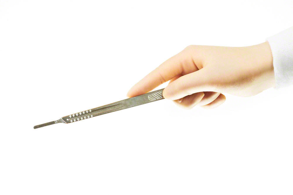 Surgical instrument (scalpel handle) held by surgeons hand
