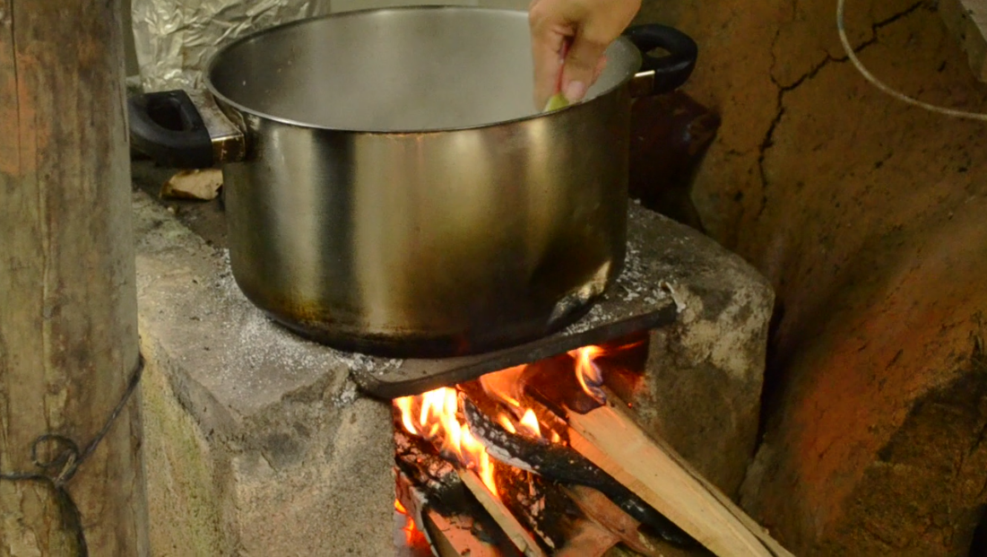  Mariana cooks rice pudding on the outdoor wood-powered stove. &nbsp;Cooking it over the fire gives it a richer taste, as the smoke intertwines with the flavors of the pudding. 