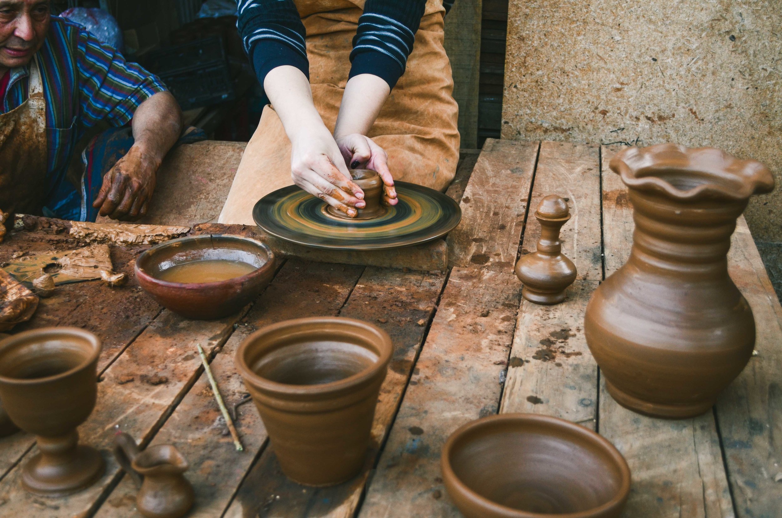  A student tries her hand at pottery under the watch of the artisanal potter in Buín 