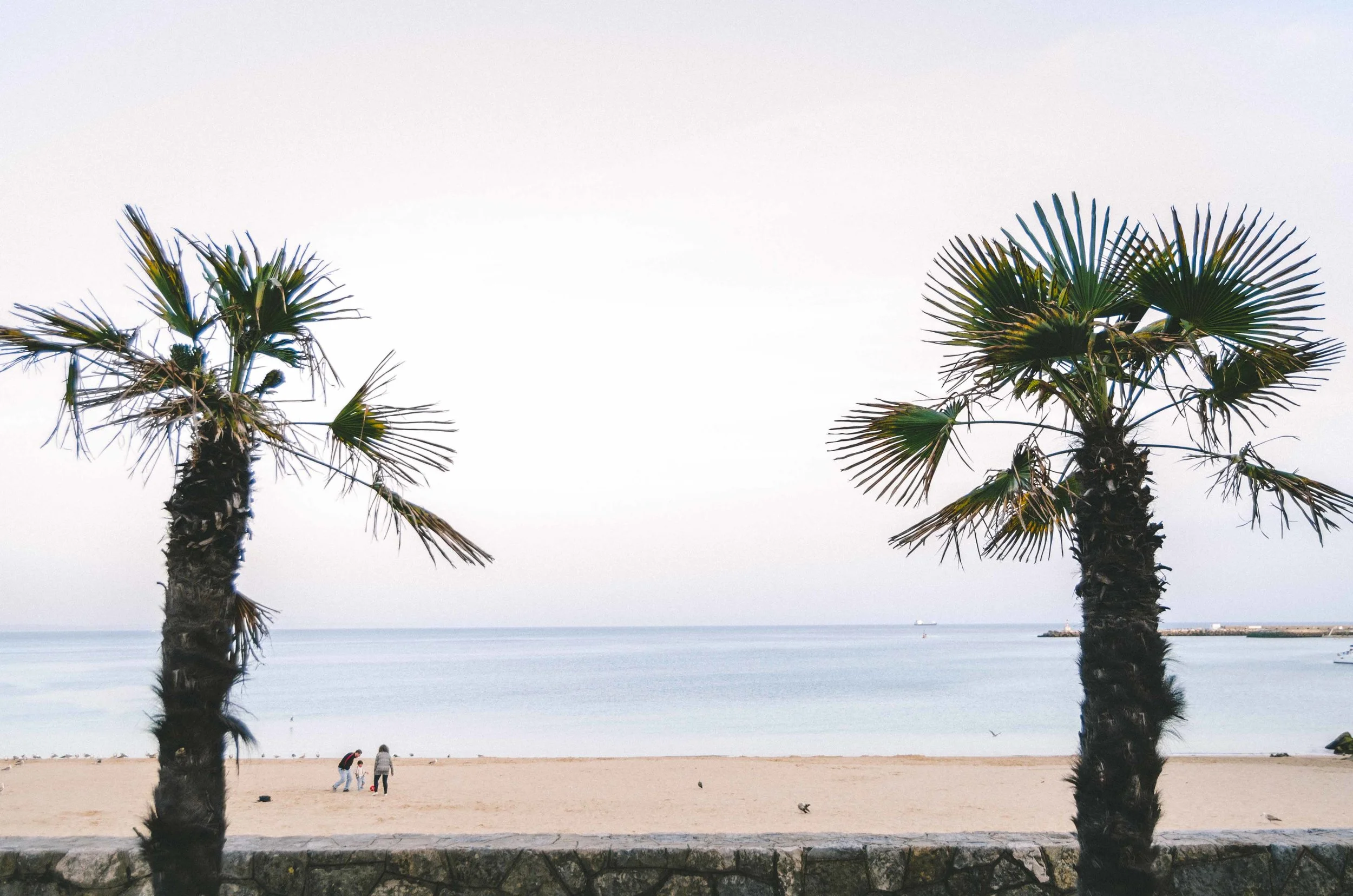 A young family playing soccer on the beach <3