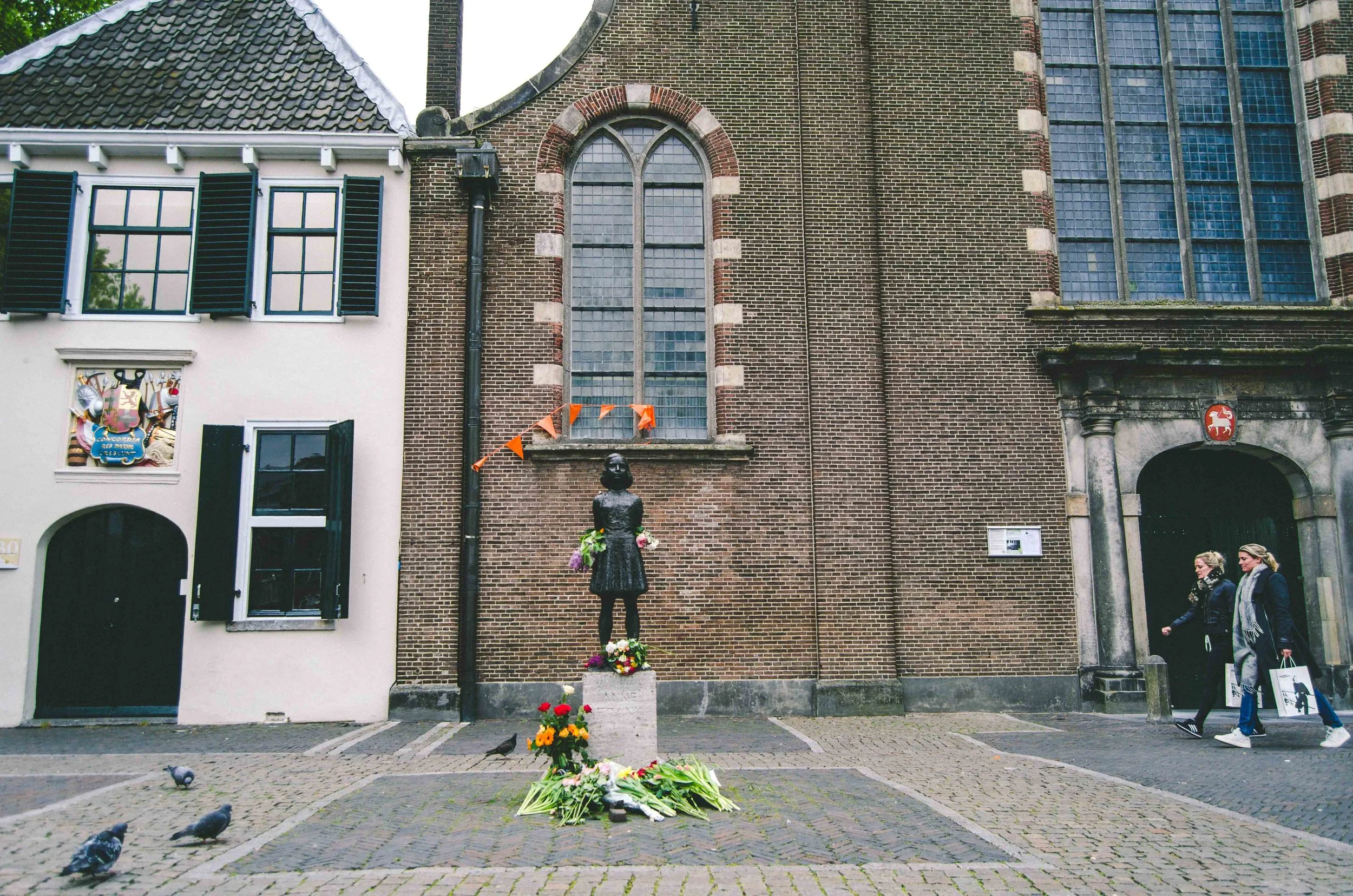 Anne Frank memorial statue on her birthday + orange flags in honor of King's Day (Koningsdag)