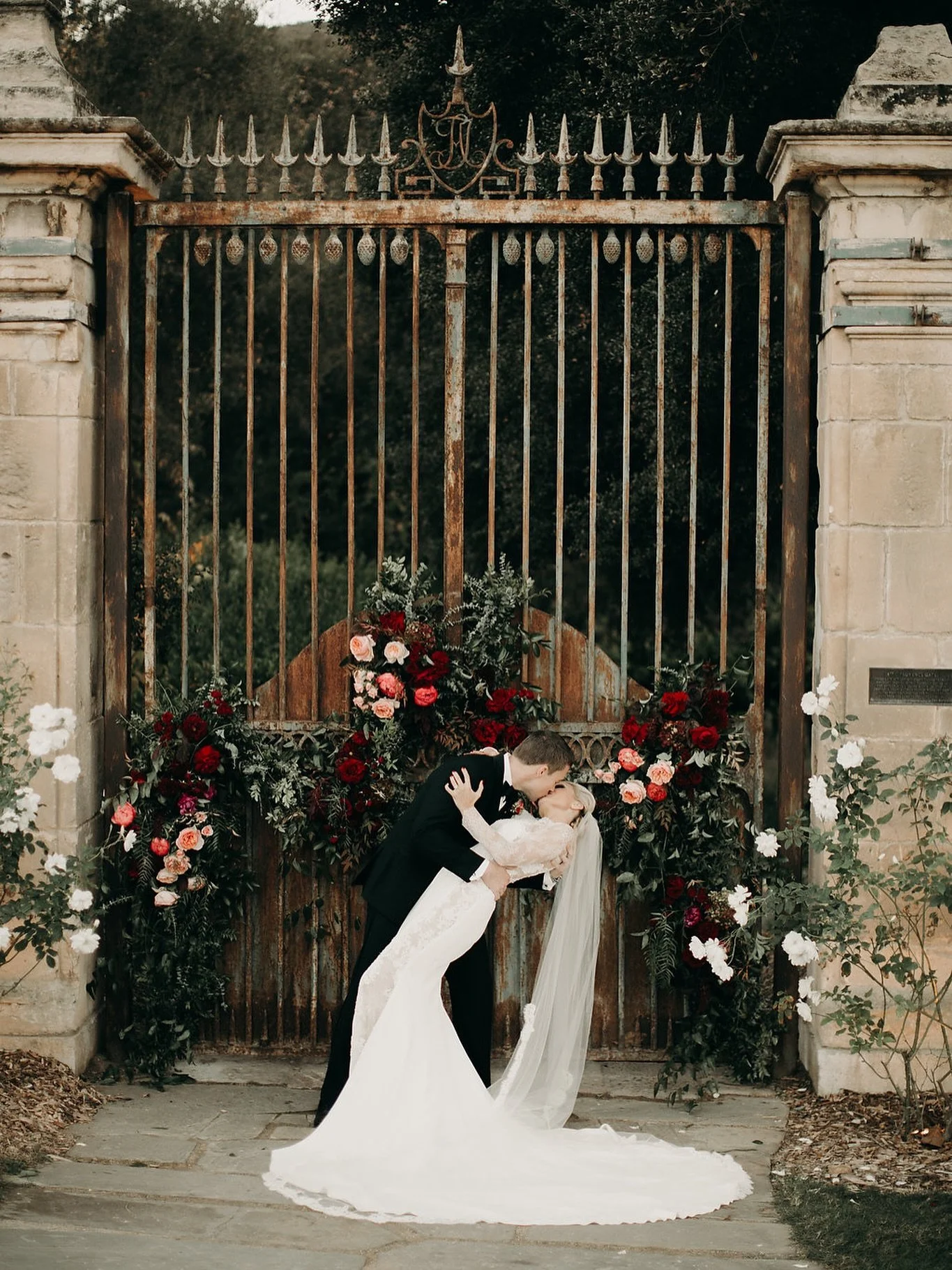 A love strong enough to stop time&hellip; and maybe open gates.
(But let&rsquo;s be honest&mdash;he&rsquo;s lucky she said yes.)

Flanked by blooms and history, they sealed it with a kiss.
Forever begins here. 
.
.
.
 #ceremonybackdrop #gardenwedding