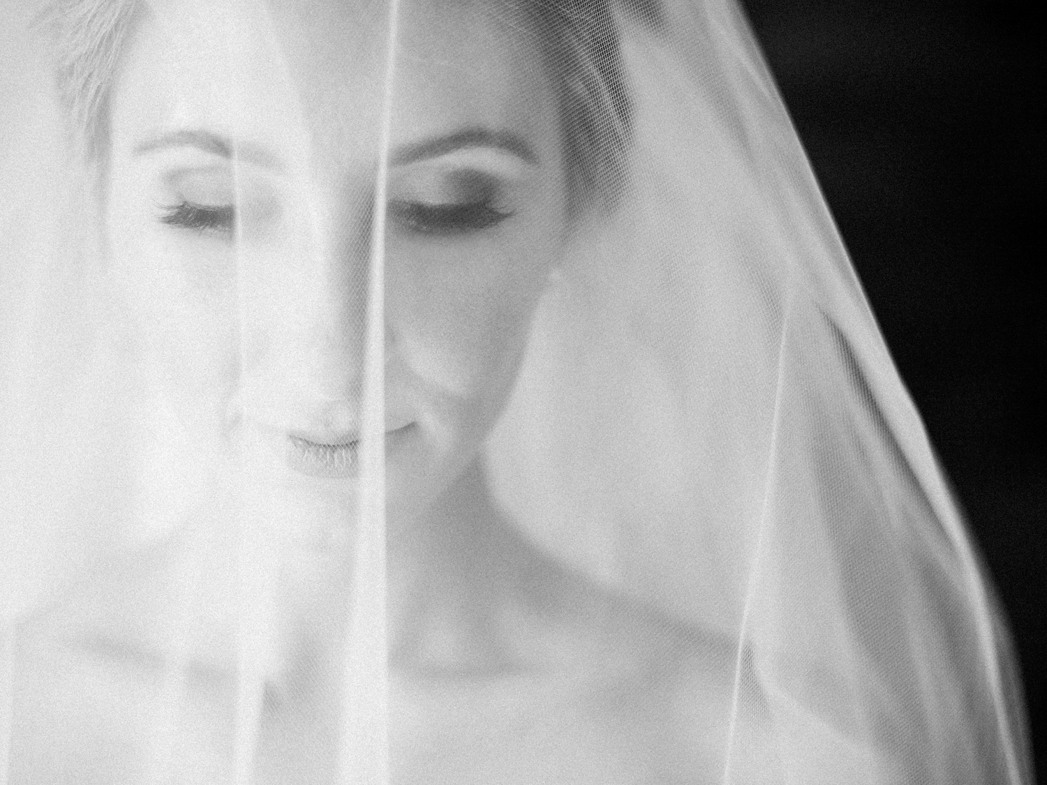 Black and white portrait of a bride in her veil getting ready