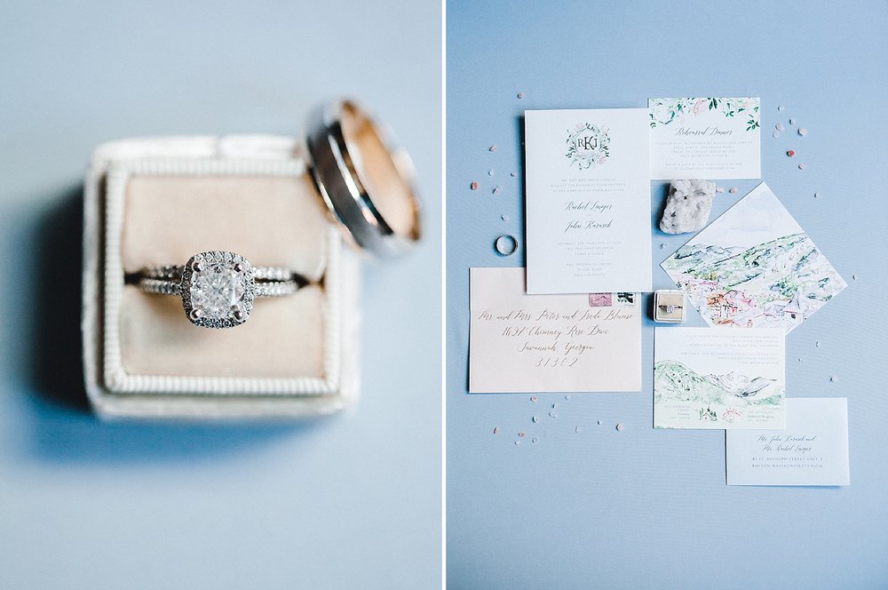 A velvet ring box and watercolor invitation suite on a blue styling board