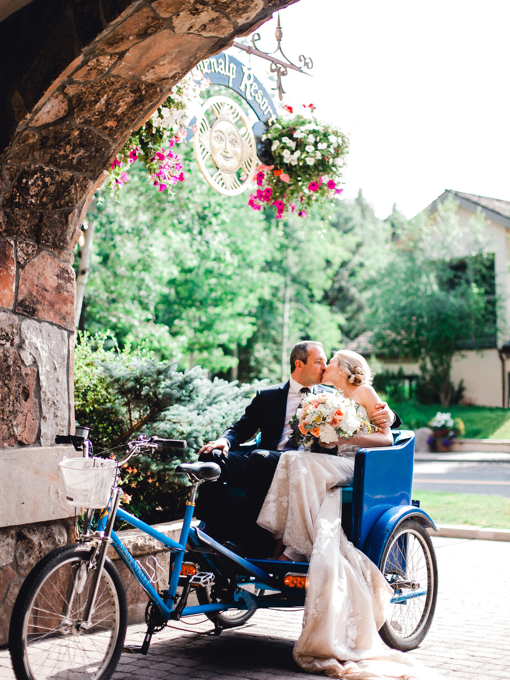 Bride and Groom arriving for their wedding reception at the Sonnenalp in a pedicab