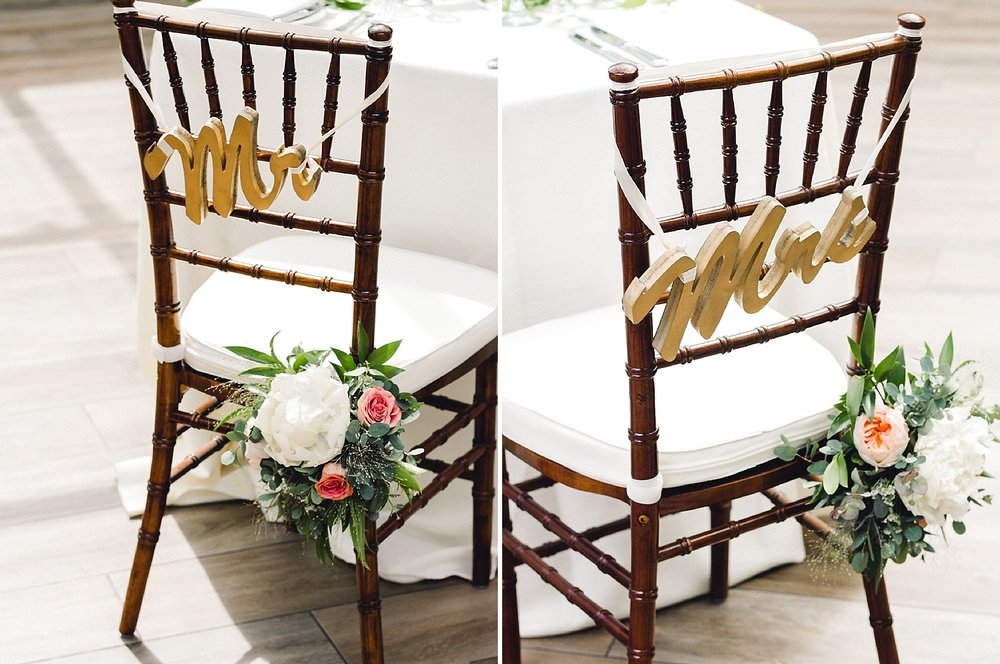 chiavari chairs with mr and mrs signs and flowers for a wedding reception