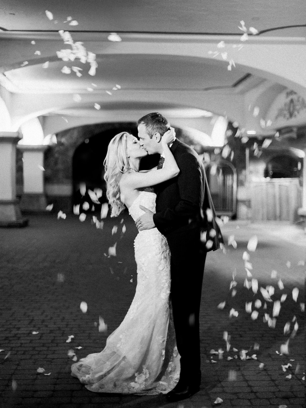 Black and white grand exit photo with petal toss outside