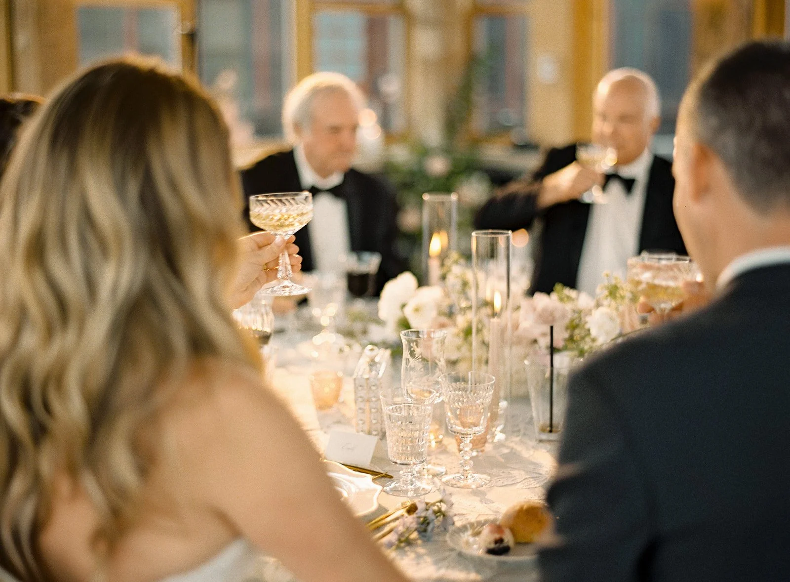 Guests gathered around the table during an intimate black-tie wedding dinner.