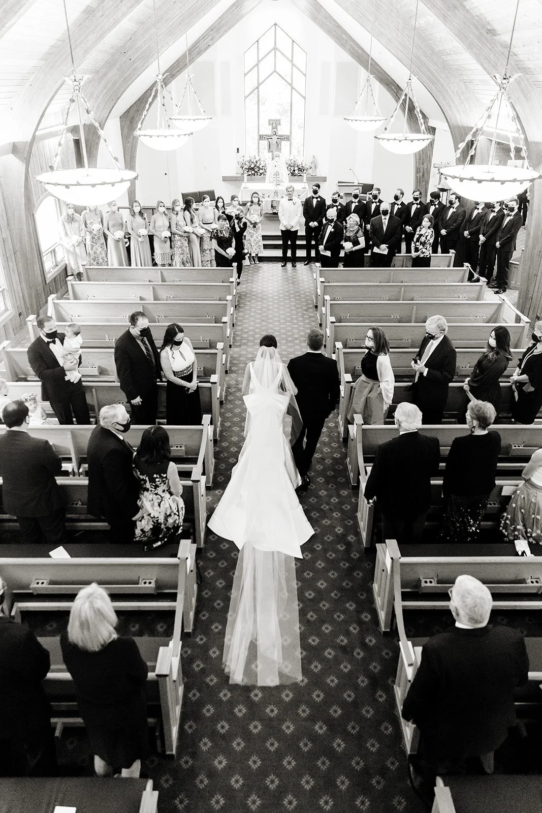 Bride walking down the aisle inside the Vail Interfaith Chapel in Vail, Colorado