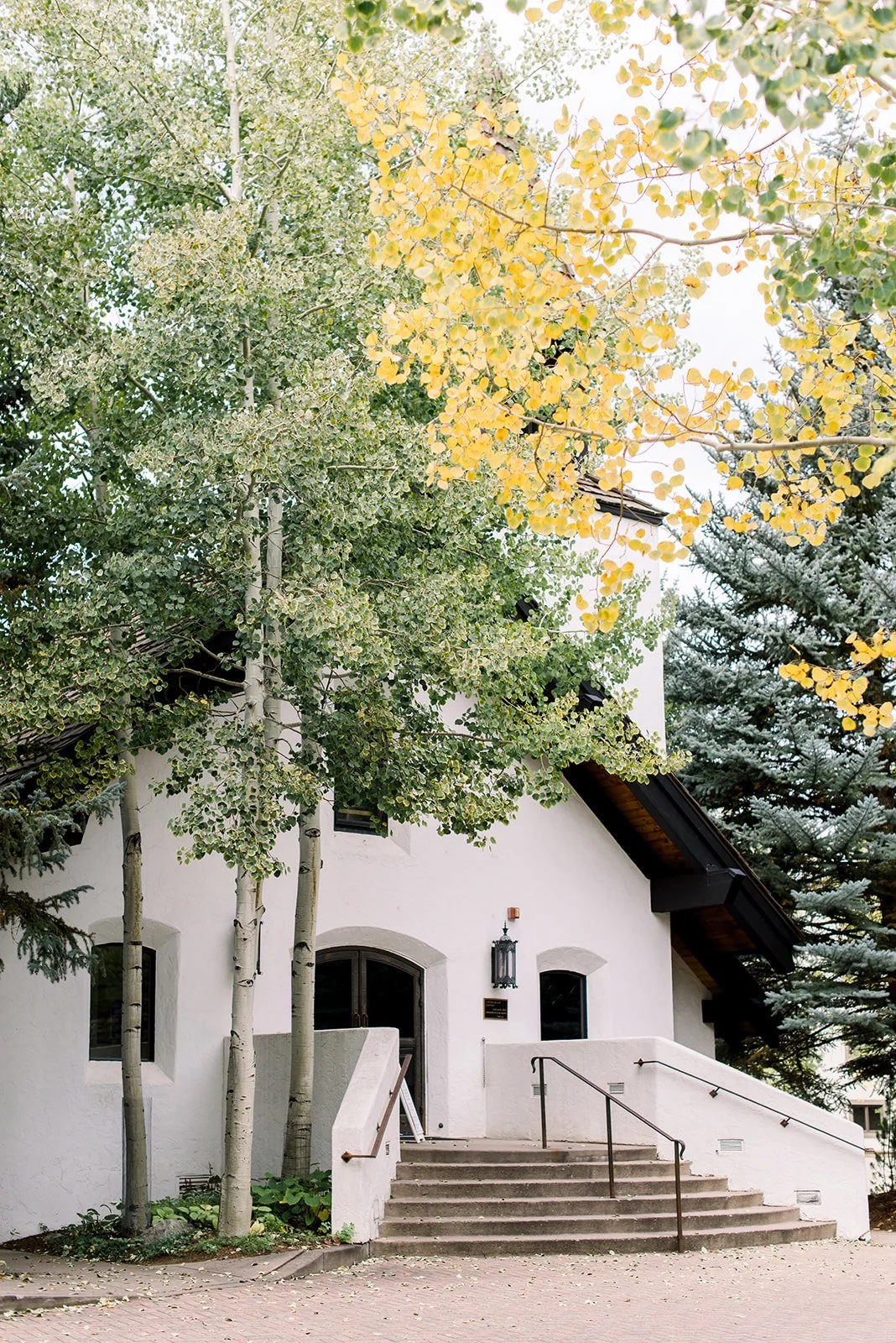 Vail Interfaith Chapel surrounded by green and golden autumn trees.