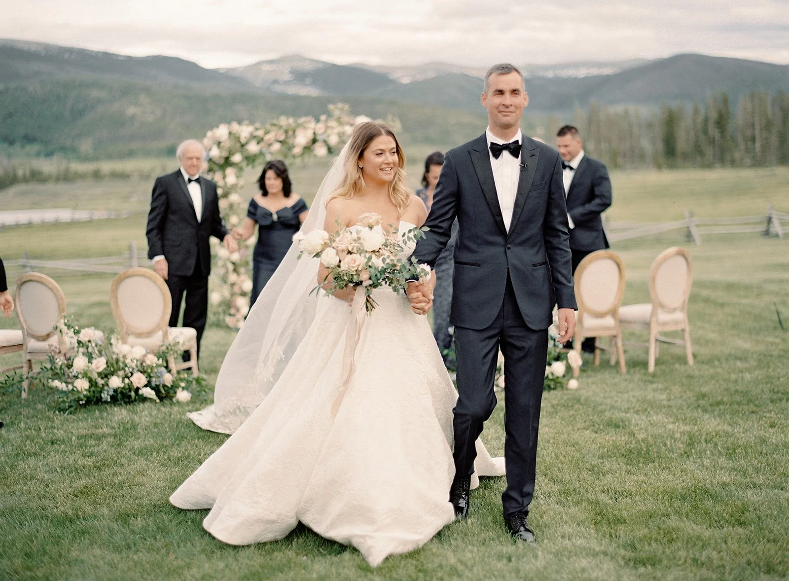 Newlyweds walking down the aisle after their mountain wedding ceremony.