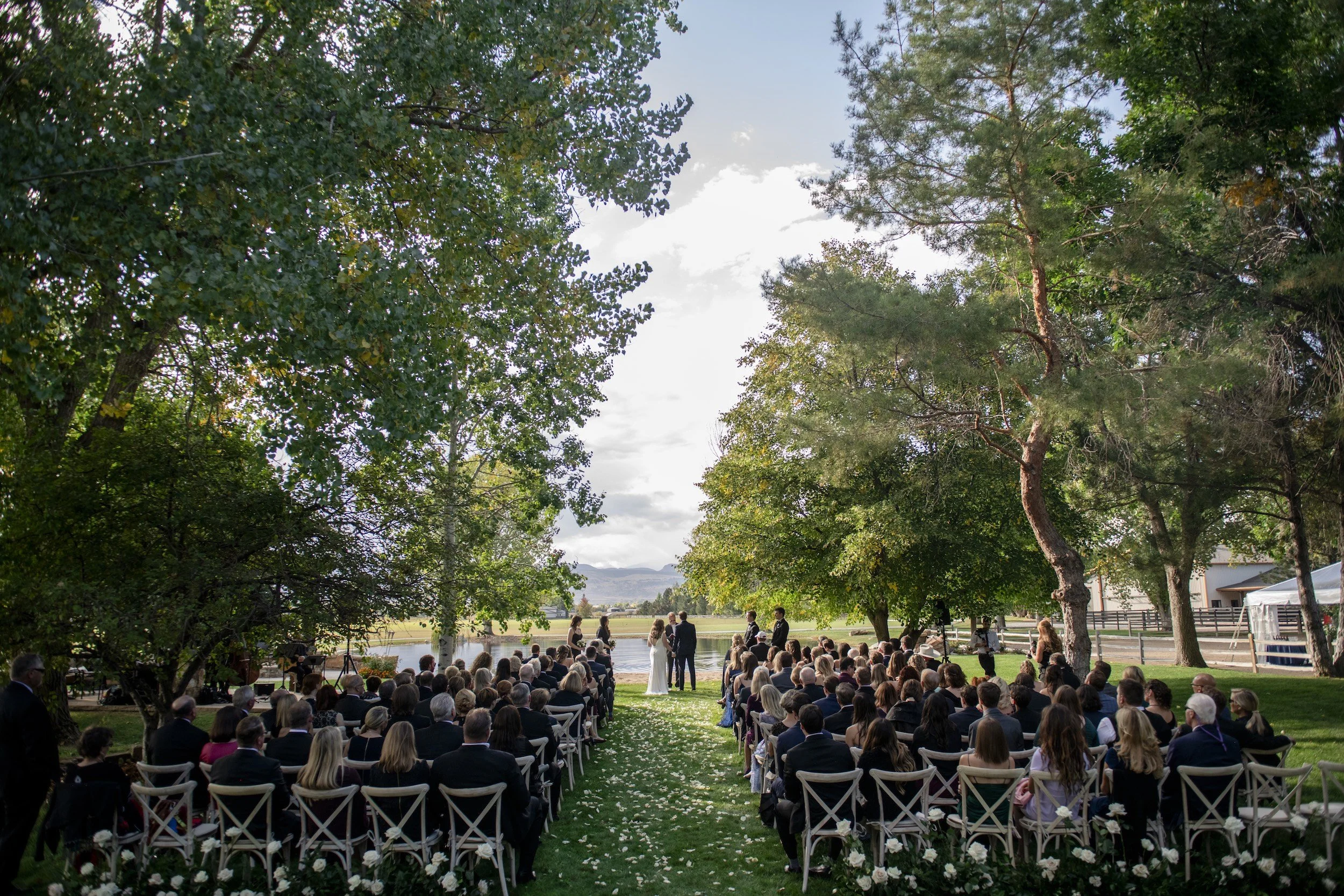 Outdoor wedding ceremony framed by trees at a private estate in Colorado