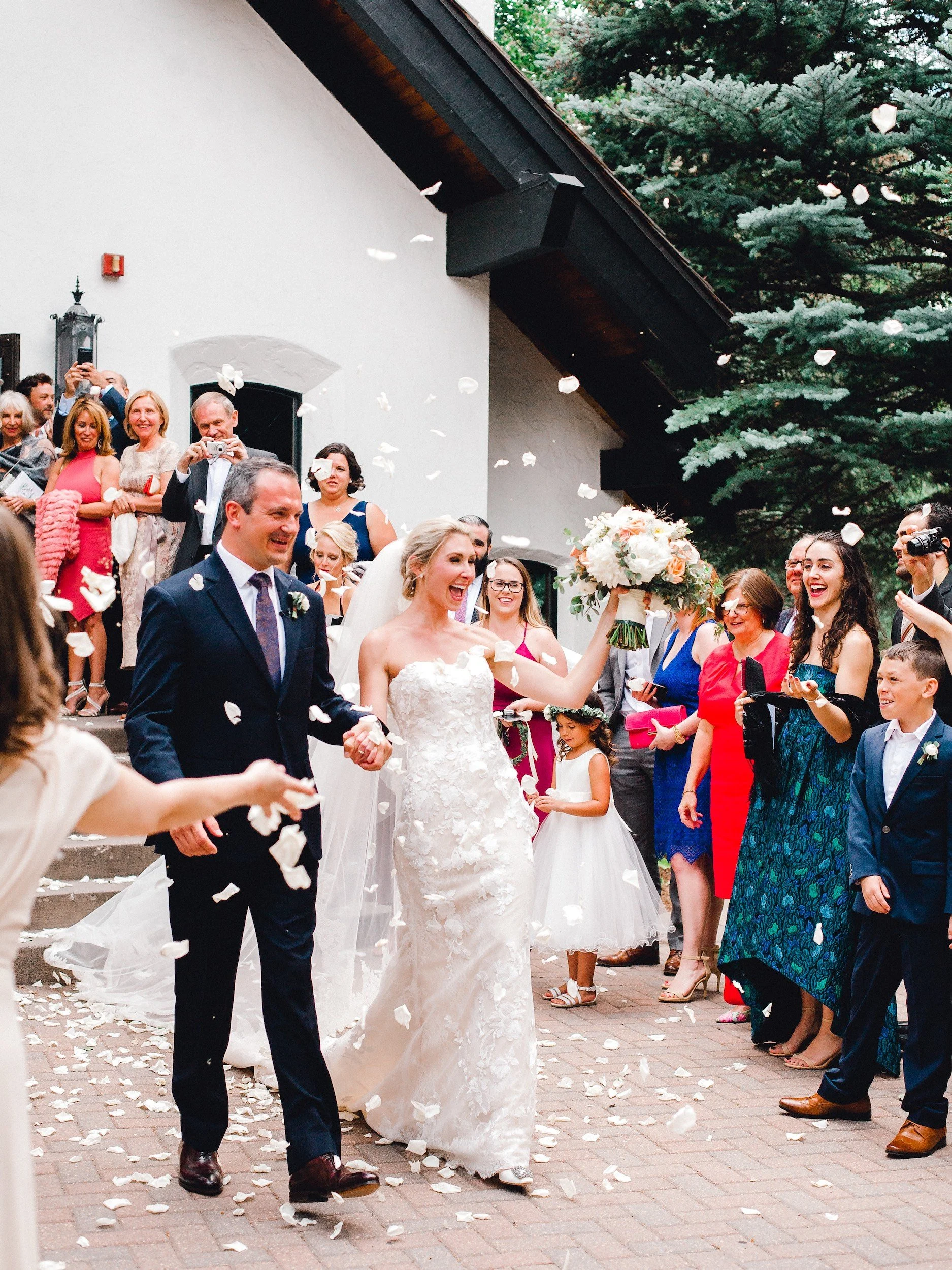 Newlyweds celebrating as they exit their Colorado wedding ceremony at the Vail Interfaith Chapel