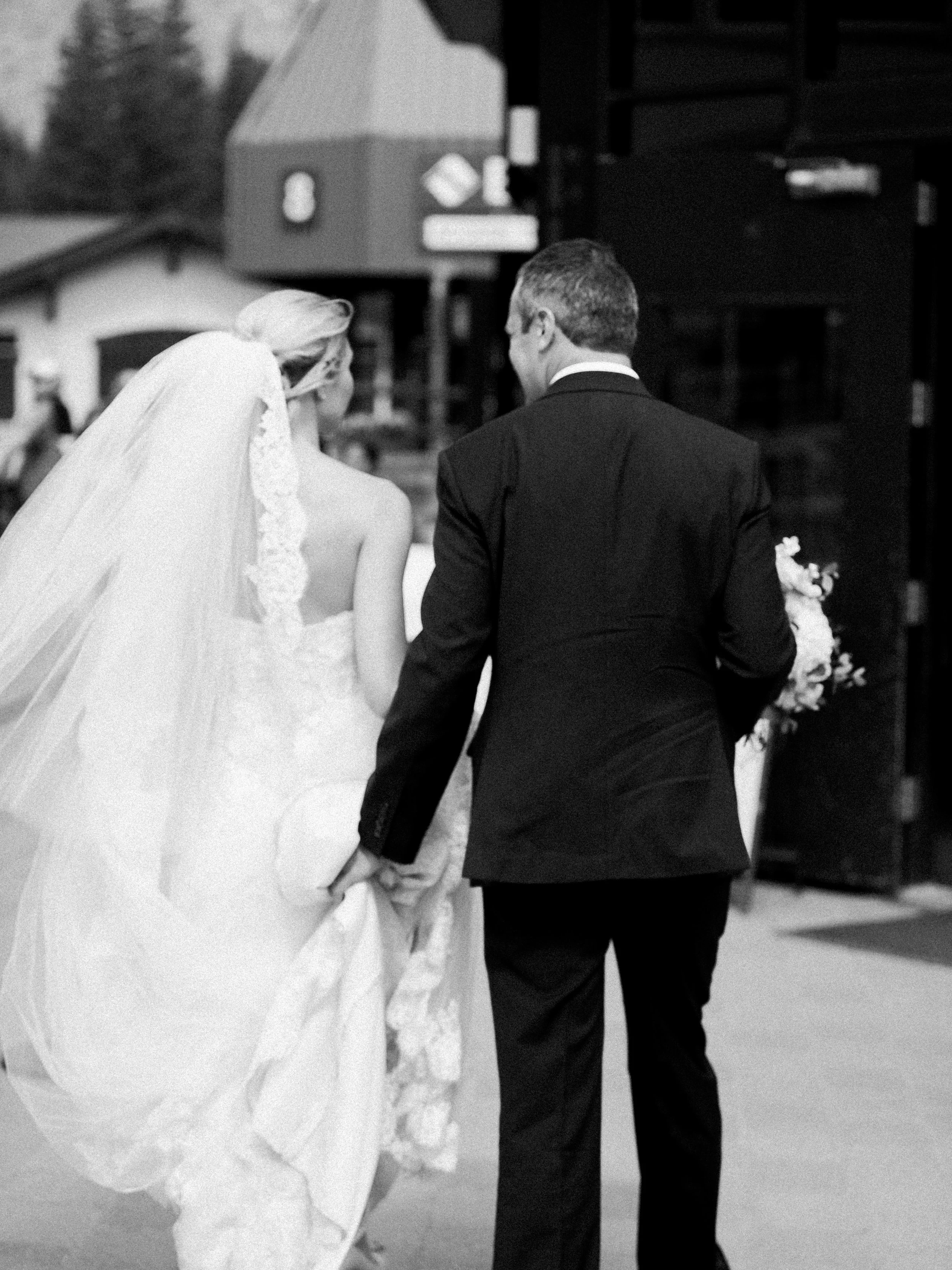 Bride and groom walking through Vail Village after their wedding ceremony