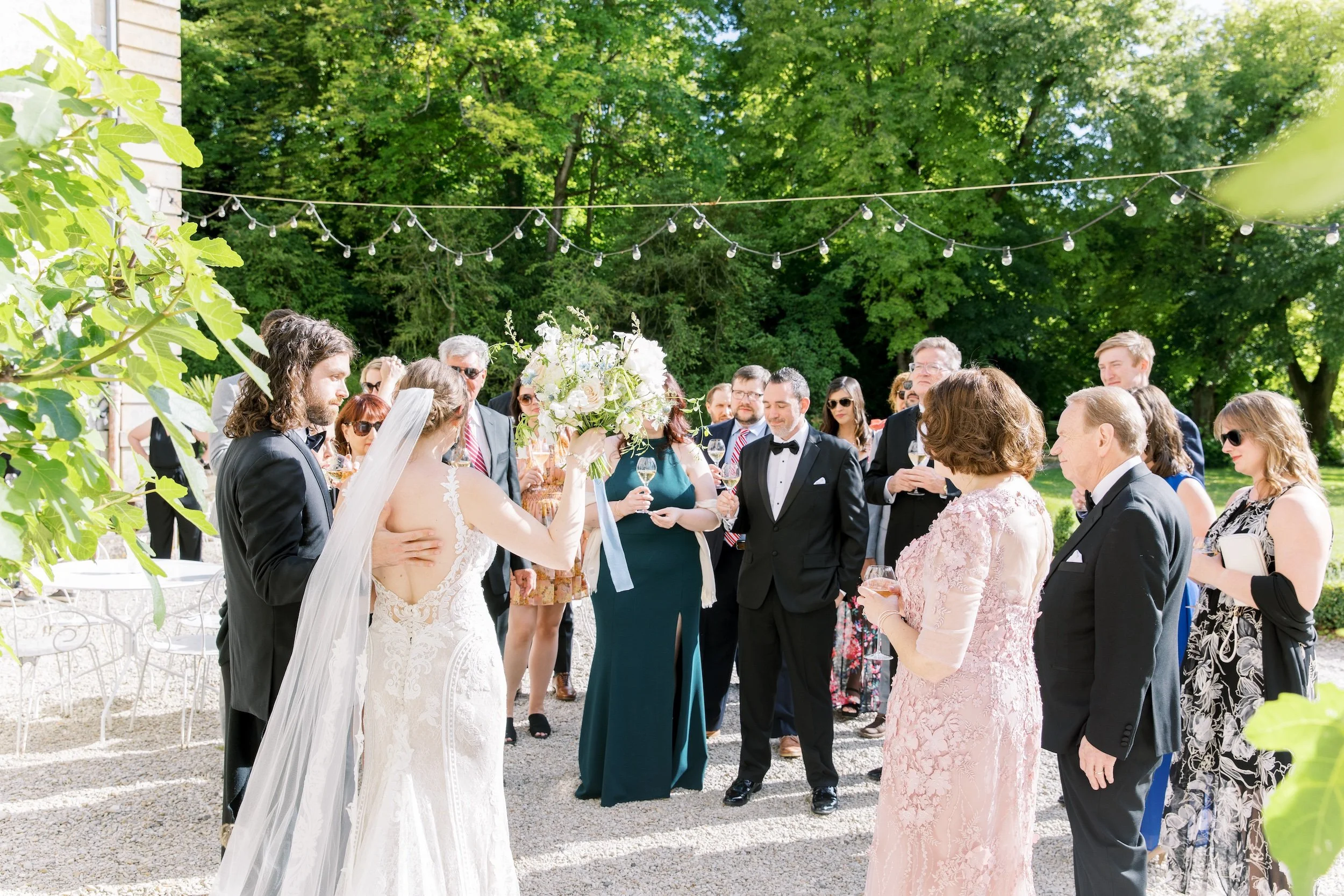 Wedding guests and the newlyweds celebrating together at an outdoor summer wedding at Chateau de Mairy