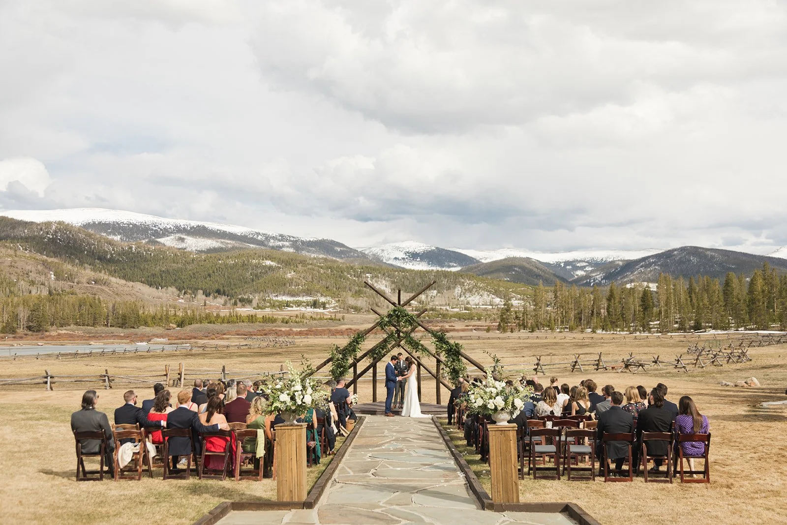 Outdoor wedding ceremony at Devil's Thumb Ranch in a Colorado mountain setting, showing how ceremony layout, scale, and landscape influence planning and guest experience.