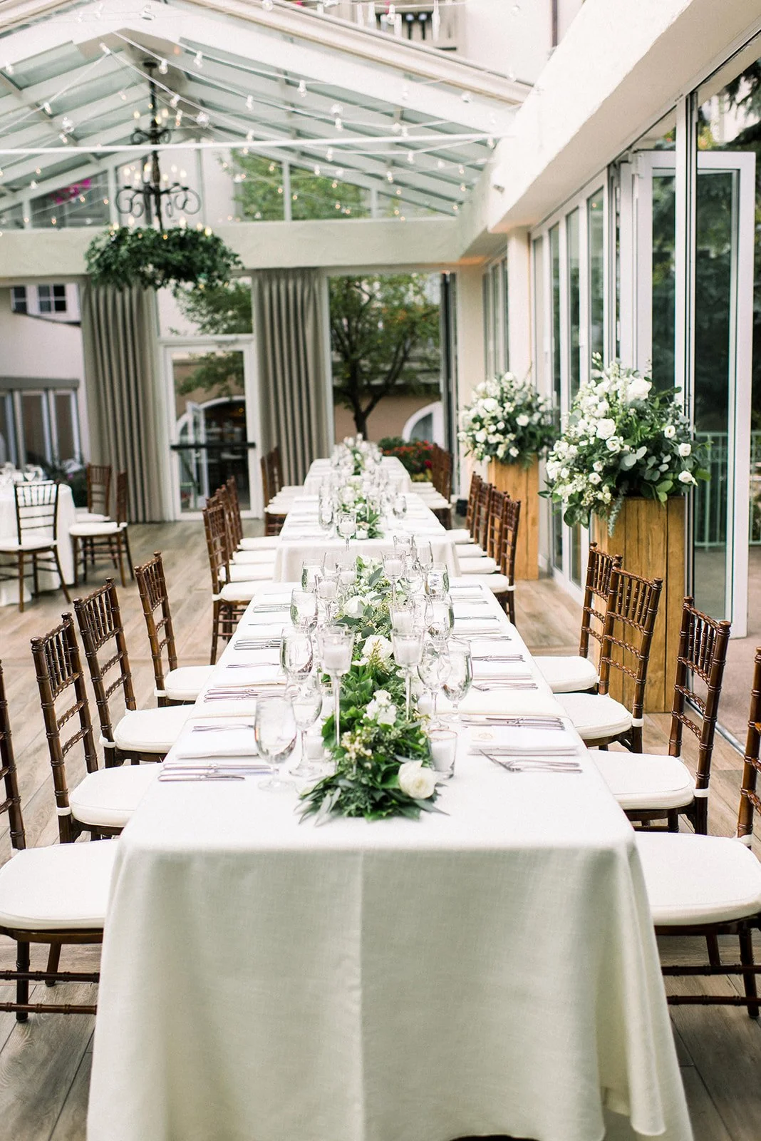 Long reception table decorated with white flowers and greenery at The Sonnenalp.