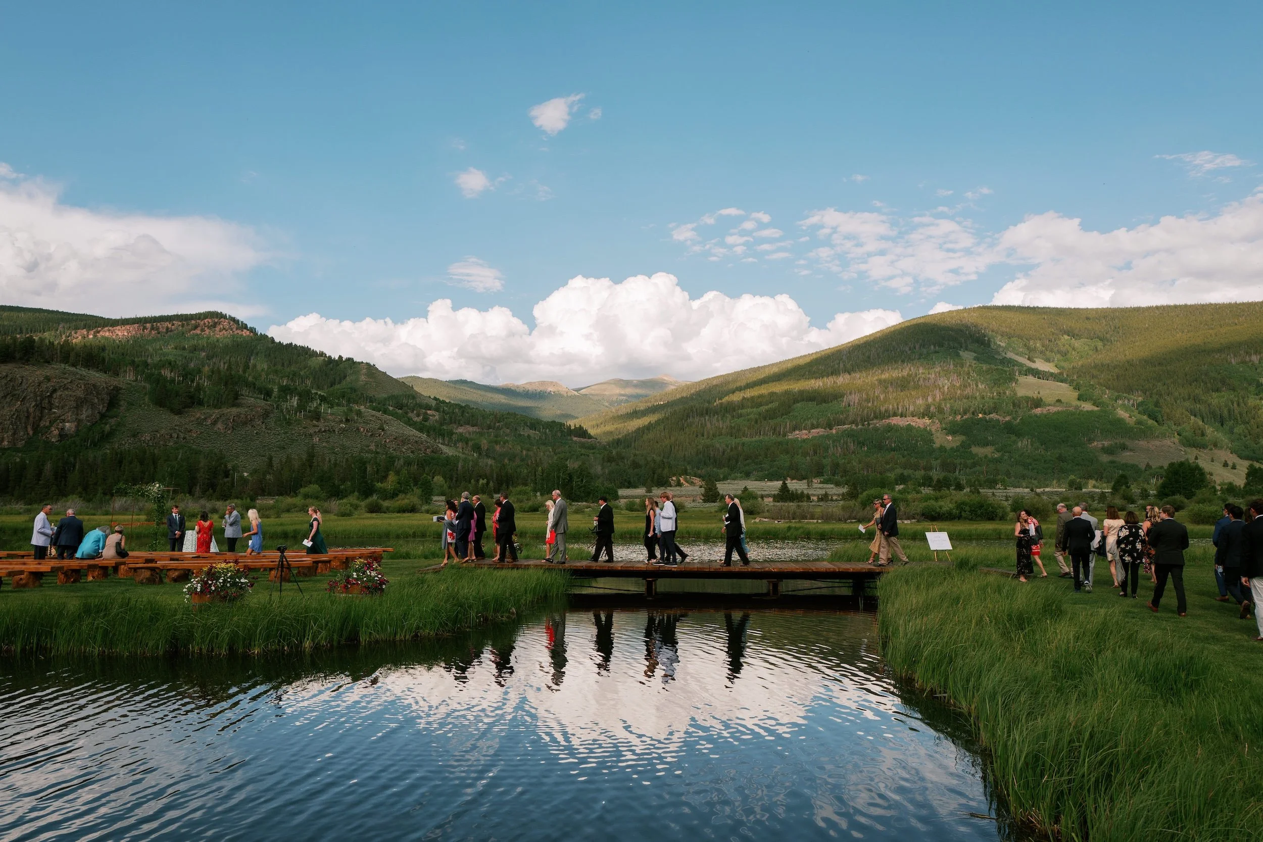 Outdoor wedding ceremony beside a mountain lake at Camp Hale in Colorado