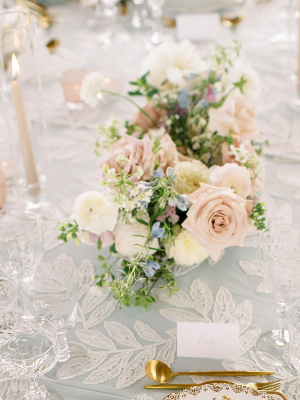 Soft blush flowers and antique tableware arranged for an intimate black-tie wedding.