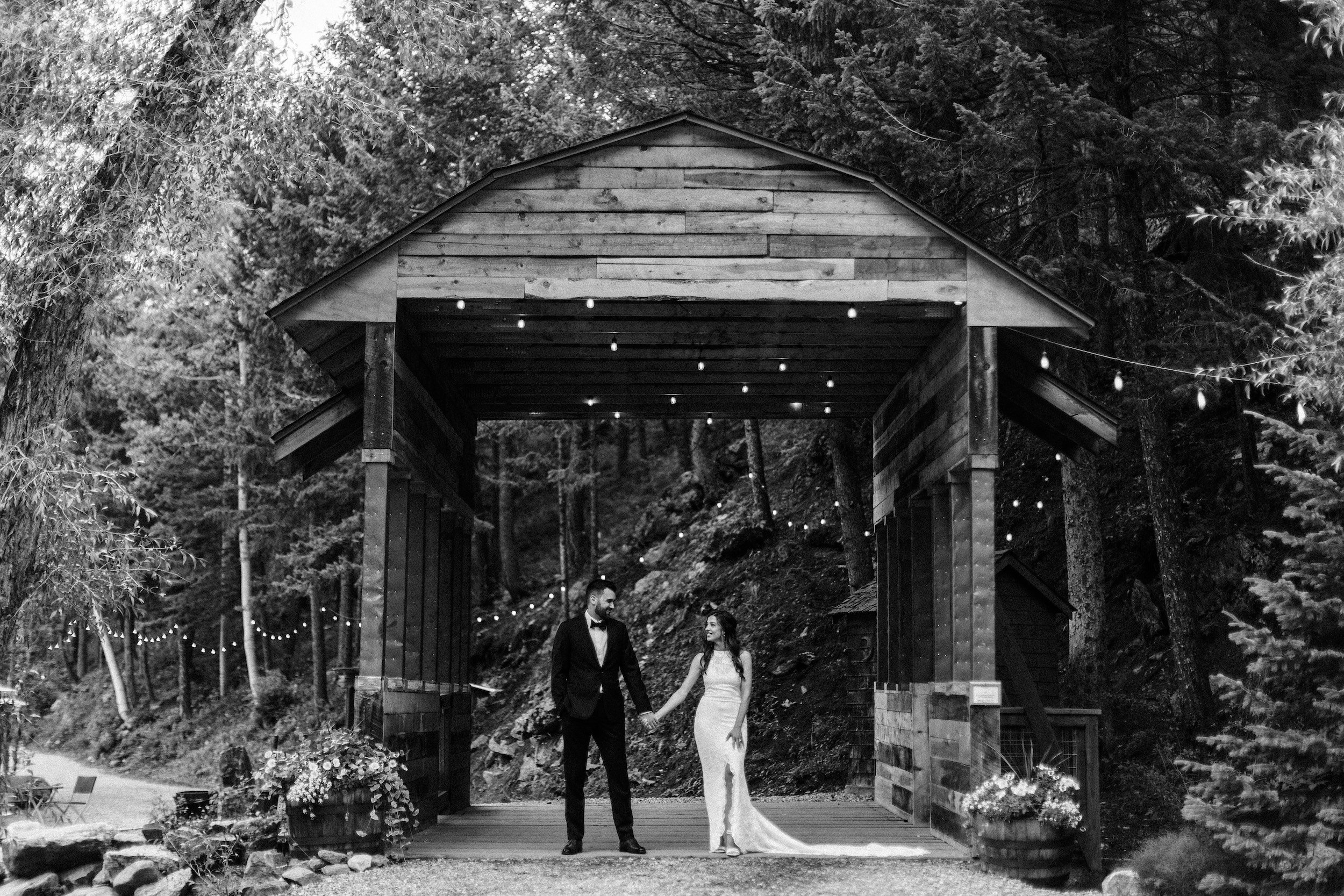 Wedding couple beneath a rustic wooden bridge at Blackstone Rivers Ranch