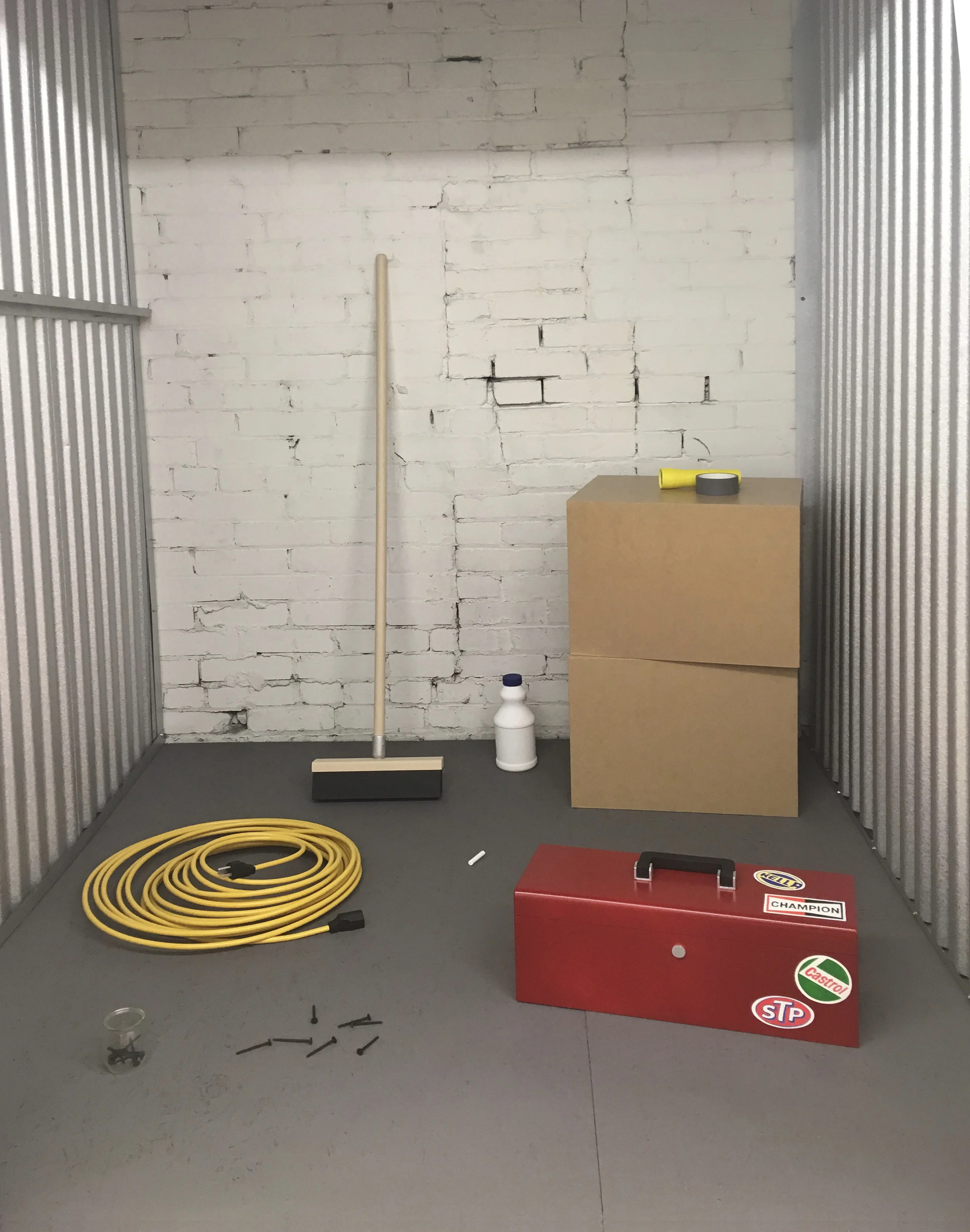 Concieved of for ‘Holding Patterns’, an exhibition of work in a storage locker facility, Occupant asks how spurious narratives arise from only partial information. How does our brain fill in the blanks? Presenting a collection of objects meticulously replicated by the artist using acrylic paint on MDF, wood and copper " Occupant " asks the viewer to draw connections between disparate objects, while alluding to the sometimes nefarious ways that storage units are put to use.