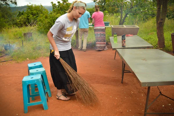 Emily diligently sweeping the yard